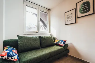 a green couch in a room with a window at Apartment Via Mons in Kranjska Gora