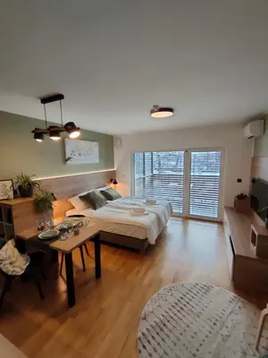 a bedroom with a bed and a table in a room at Apartments & Burgers REZIDENCA PIPANOVA in Ljubljana