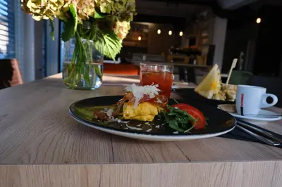 two plates of food on a table with a vase of flowers at Apartments & Burgers REZIDENCA PIPANOVA in Ljubljana