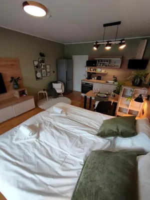 a large white bed in a room with a kitchen at Apartments & Burgers REZIDENCA PIPANOVA in Ljubljana