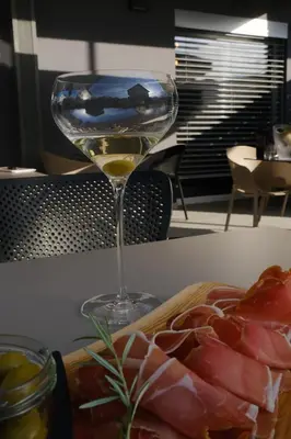 a glass of wine next to a plate of meat at Apartments & Burgers REZIDENCA PIPANOVA in Ljubljana