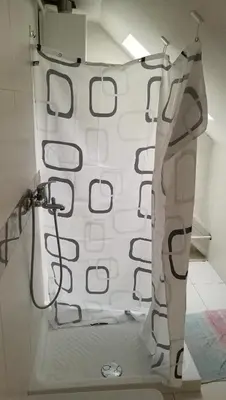 a white shower curtain hanging on a wall at Most Hostel in Ljubljana