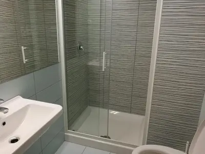 a bathroom with a glass shower and a sink at Most Hostel in Ljubljana