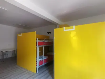 a room with two yellow walls and a bunk bed at Most Hostel in Ljubljana