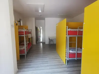 a room with several bunk beds and a hallway at Most Hostel in Ljubljana