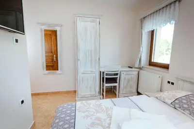 a white bedroom with a bed and a desk at Zelena Oaza - B&B in Miklavž pri Ormožu