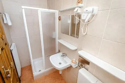 a white bathroom with a shower and a sink at Zelena Oaza - B&B in Miklavž pri Ormožu