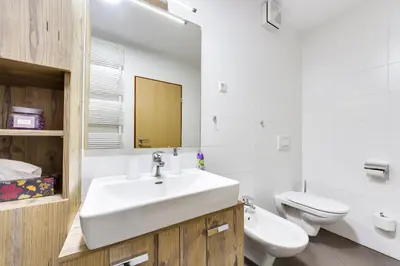 a white bathroom with a sink and a toilet at J&M Holiday Home Moravske Toplice in Moravske Toplice