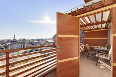 a balcony with a wooden door and a table at J&M Holiday Home Moravske Toplice in Moravske Toplice