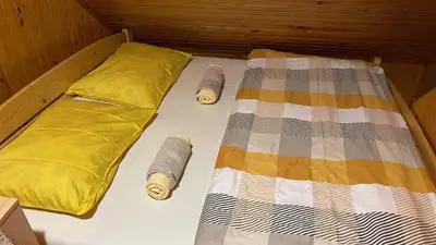 a bed with two pillows and a blanket at Velika planina Chalet SLOVENKA in Stahovica