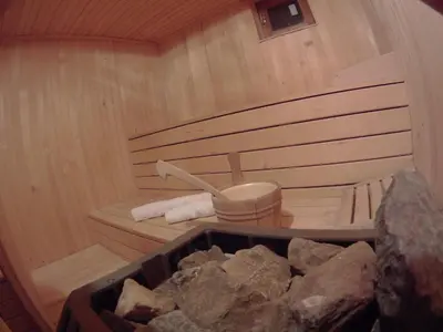 a sauna with a bucket of rocks in it at Velika planina Chalet SLOVENKA in Stahovica