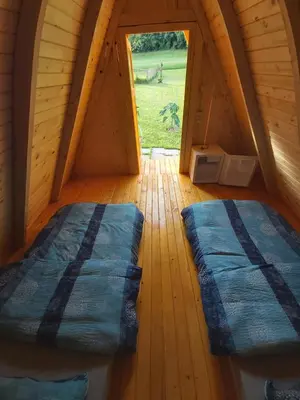 an attic room with two beds and a window at GLAMPING HIŠKe PETRIN in Tolmin