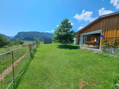 a yard with a fence next to a building at GLAMPING HIŠKe PETRIN in Tolmin