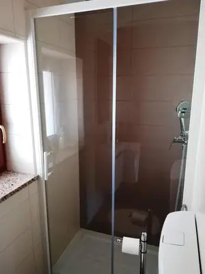 a glass shower door in a bathroom with a toilet at Prenočišča Iris in Sežana