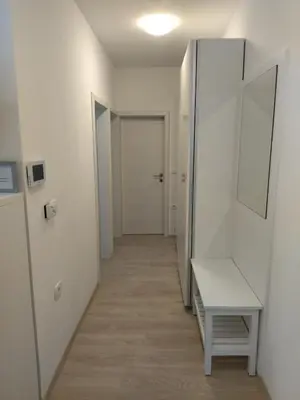 a hallway with a bench and a mirror at Apartments B&M in Sežana