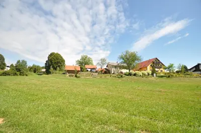 a field of grass with houses in the background at Hostel Strug in Makole