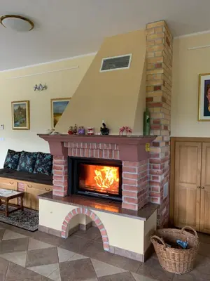a brick fireplace in a living room with a fire place at Hostel Strug in Makole