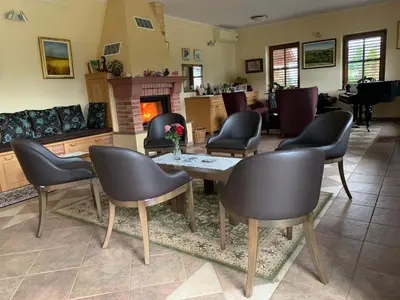 a living room with a table and chairs and a piano at Hostel Strug in Makole