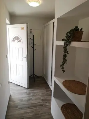 a hallway with a white door and a cross on the wall at Alpine Joy Apartments in Bohinj