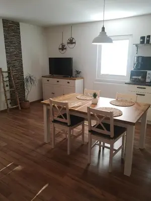 a kitchen with a table and chairs and a television at Alpine Joy Apartments in Bohinj