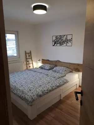 a bedroom with a bed with a wooden headboard at Alpine Joy Apartments in Bohinj