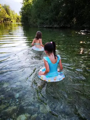 two young girls are in the water on boogie boards at Alpine Joy Apartments in Bohinj