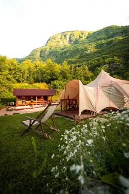 a tent and a bench and a table and a picnic table at Glamping Gozdna Jasa in Bovec