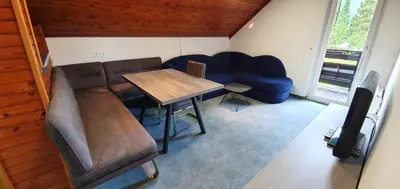 a living room with a table and a blue couch at Apartments and Rooms Milena in Kranjska Gora