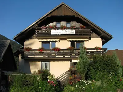 a building with flowers on the balconies and a sign on it at Apartments and Rooms Milena in Kranjska Gora