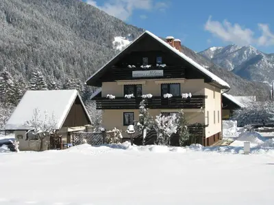 a ski lodge with snow on the ground at Apartments and Rooms Milena in Kranjska Gora