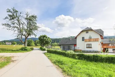 a road leading to a white house in a field at Apartments Pr Fajfarju in Bled