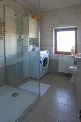 a bathroom with a washing machine and a washer at Apartments Pr Fajfarju in Bled
