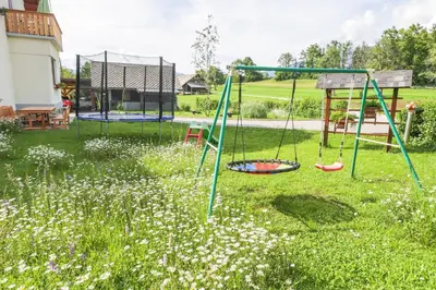 a playground with two swings in a yard at Apartments Pr Fajfarju in Bled