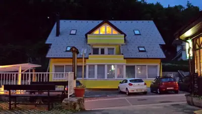 a house with two cars parked in front of it at Apartments Violeta in Bled