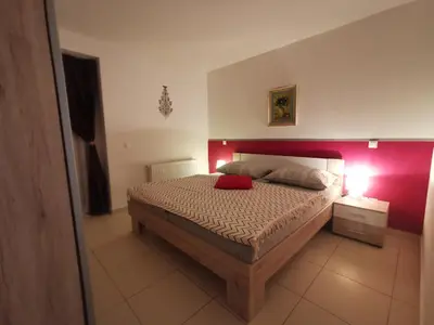 a bedroom with a bed with a red wall at Apartments Violeta in Bled