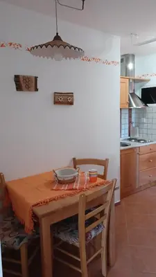 a kitchen with a wooden table with chairs and a dining room at Apartments Bobi in Tolmin