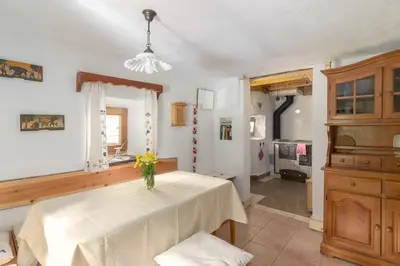 a kitchen with a table with a vase of flowers on it at Lizina hiška House Bohinj in Bohinjska Bistrica