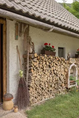 a pile of fire wood next to a house at Lizina hiška House Bohinj in Bohinjska Bistrica