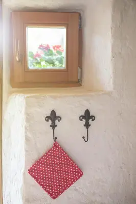 a red sign on a wall with a window at Lizina hiška House Bohinj in Bohinjska Bistrica