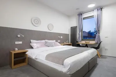 a bedroom with a large bed and a desk and a window at Vila Emona - Central Apartments - Free Parking in Ljubljana