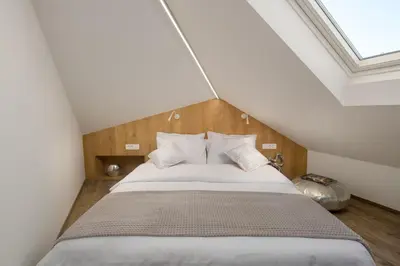 a bedroom with a large bed in a attic at Vila Emona - Central Apartments - Free Parking in Ljubljana