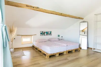 a bedroom with a bed and a wooden floor at Štulceva Hiša in Most na Soči