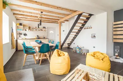 a kitchen and dining room with yellow chairs and a table at Štulceva Hiša in Most na Soči