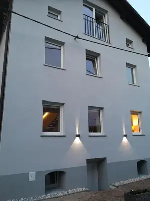 a white building with windows and lights on it at Štulceva Hiša in Most na Soči