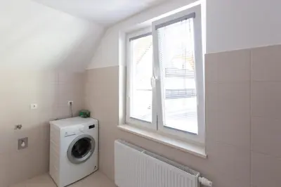 a laundry room with a washing machine and a window at Villa Melody in Bohinj