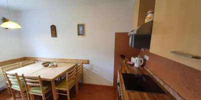 a small kitchen with a wooden table and chairs at Apartma Majda in Kranjska Gora