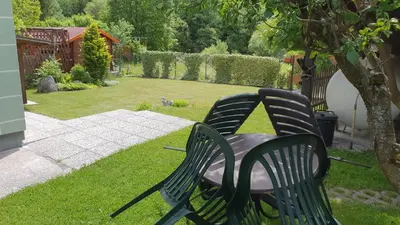 two black chairs and a table in a yard at Apartma Majda in Kranjska Gora