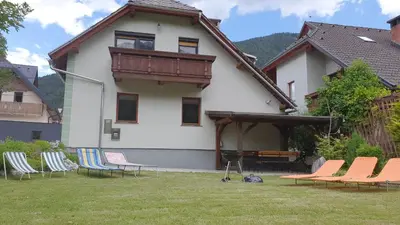a group of chairs in the yard of a house at Apartma Majda in Kranjska Gora