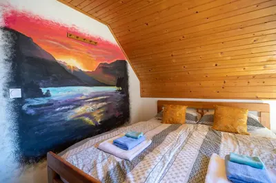 a bedroom with a bed with a painting on the wall at Sobe Ličef in Bohinj