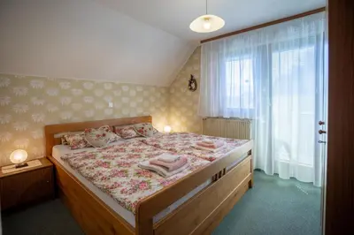 a bedroom with a large bed with a wooden frame at Sobe Ličef in Bohinj